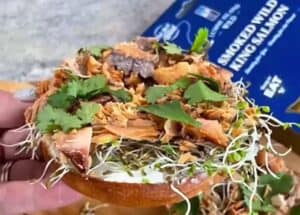 Smoked king salmon on a bagel with cream cheese and fresh sprouts